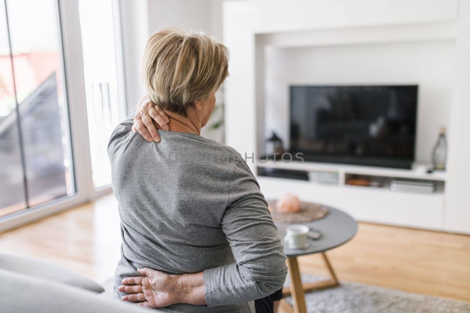 Elderly woman at home with lower back pain