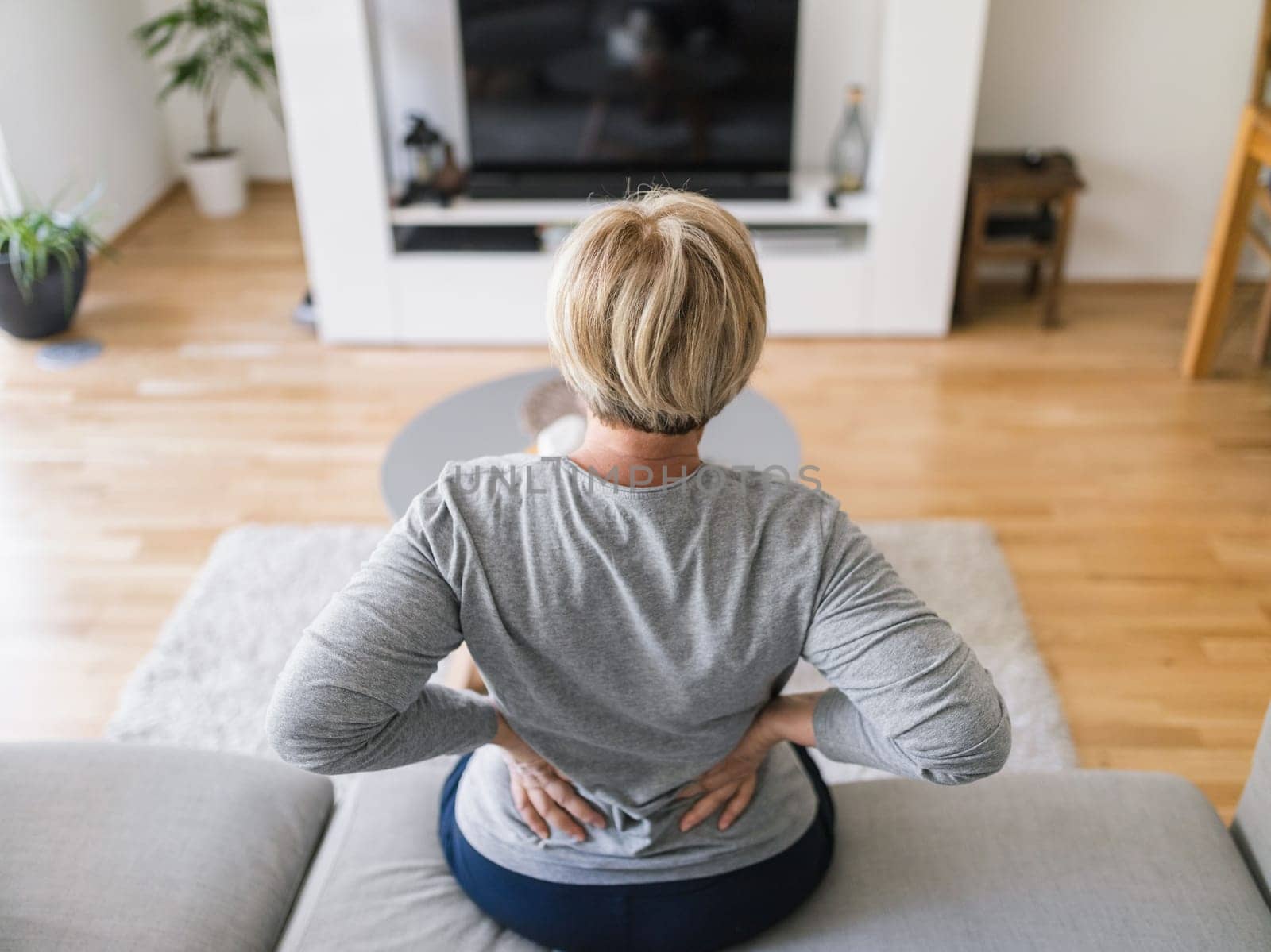Elderly woman at home with lower back pain