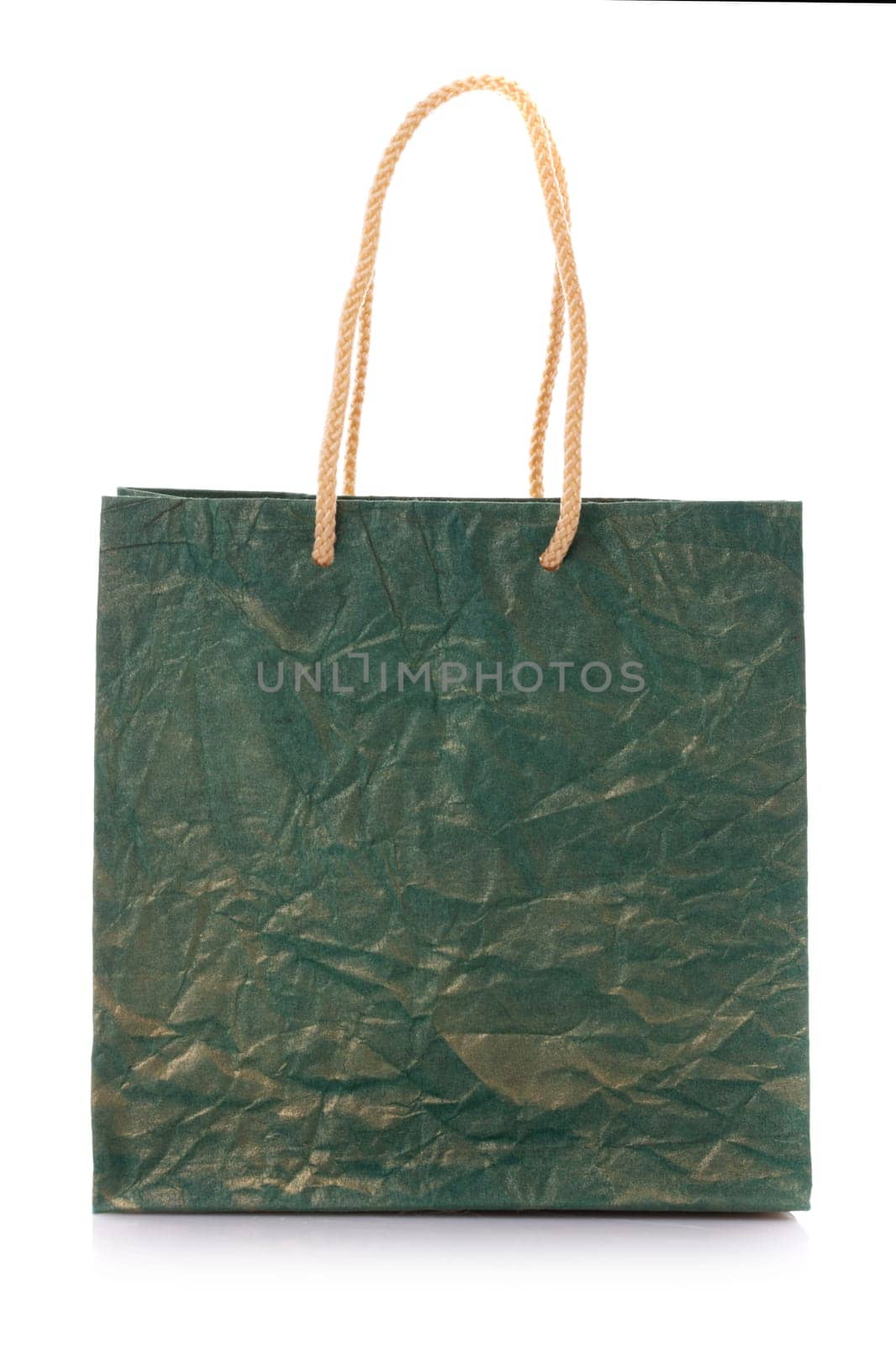 Close up of blank dark green nacre gift bag with raised handles. Package is made of crepe paper. Consumer pack ready for logo design. Isolated on a white background.