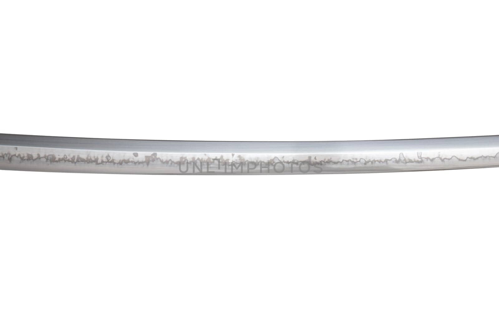 Japanese sword blade (made in China) on white background. Soft focus. The wavy pattern on the blade edge is a line of hardness that a blacksmith makes so that the blade doesn't break.