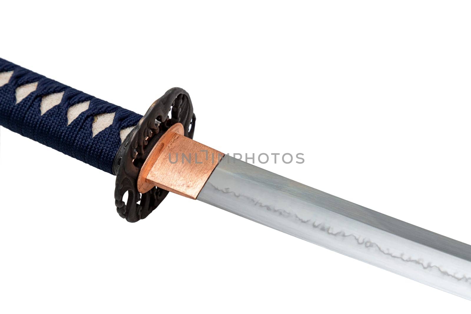 The habaki (collar) is made of polished copper. It is at the base of a Japanese sword blade with a wavy pattern on the sharp part. isolated on a white background. Selective focus.