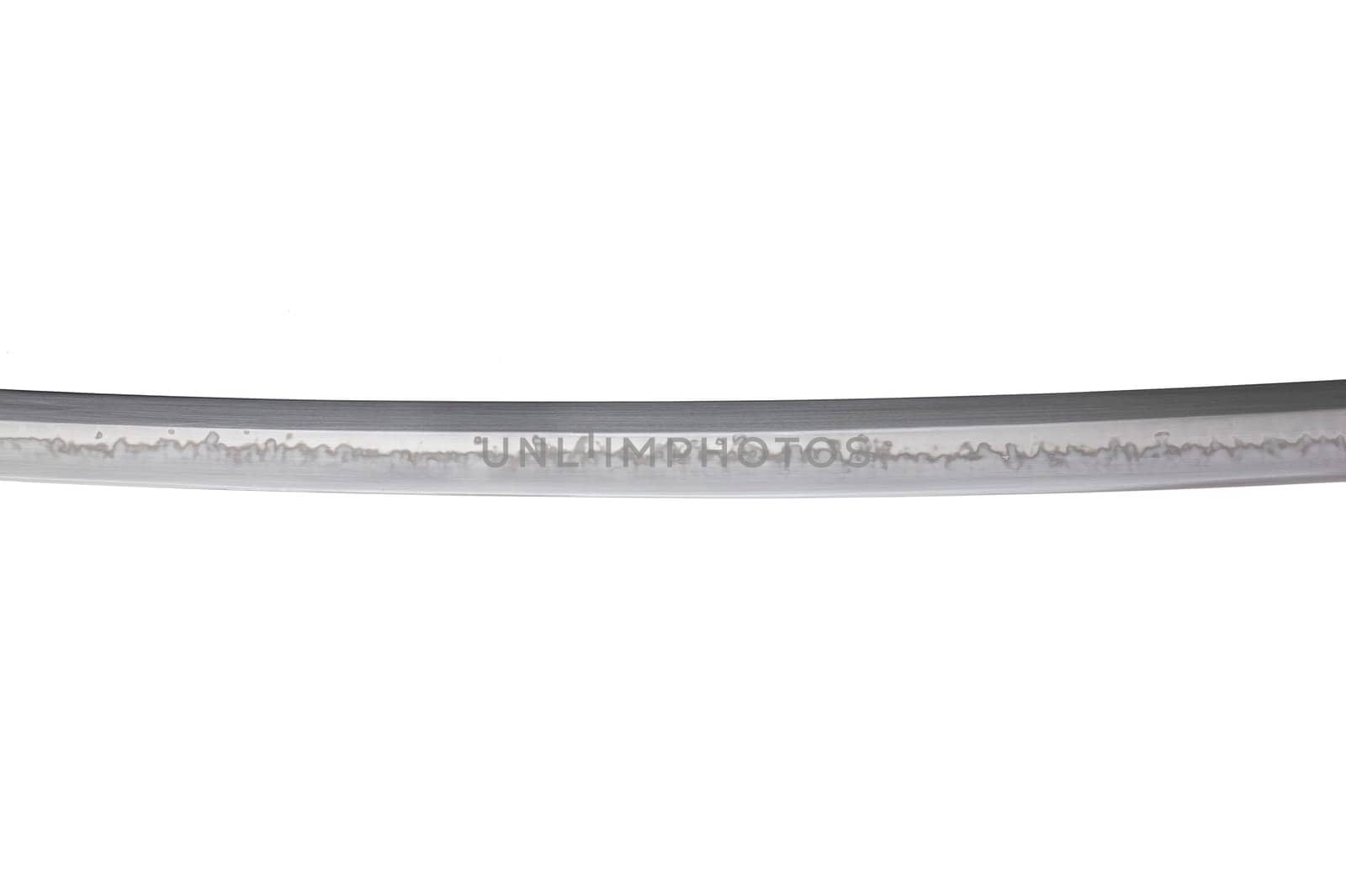 Japanese sword blade (made in China) on white background. Soft focus. The wavy pattern on the blade edge is a line of hardness that a blacksmith makes so that the blade doesn't break.