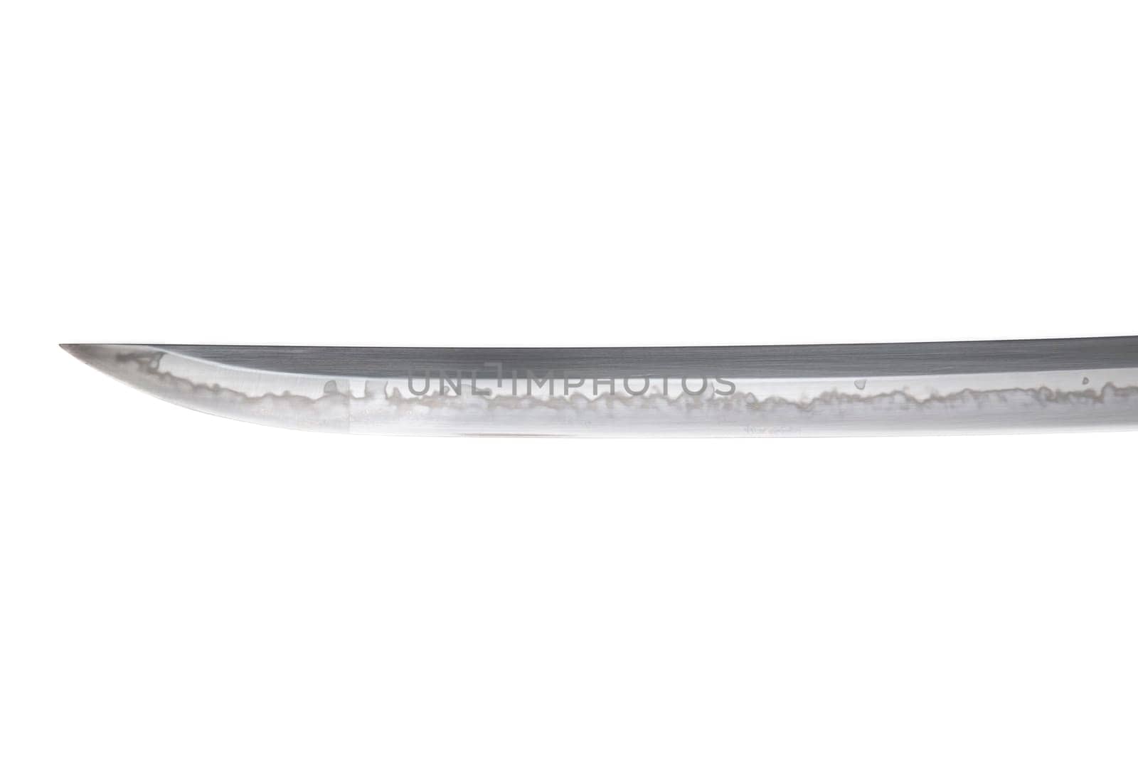 Japanese sword blade (made in China) on white background. Soft focus. The wavy pattern on the blade edge is a line of hardness that a blacksmith makes so that the blade doesn't break.