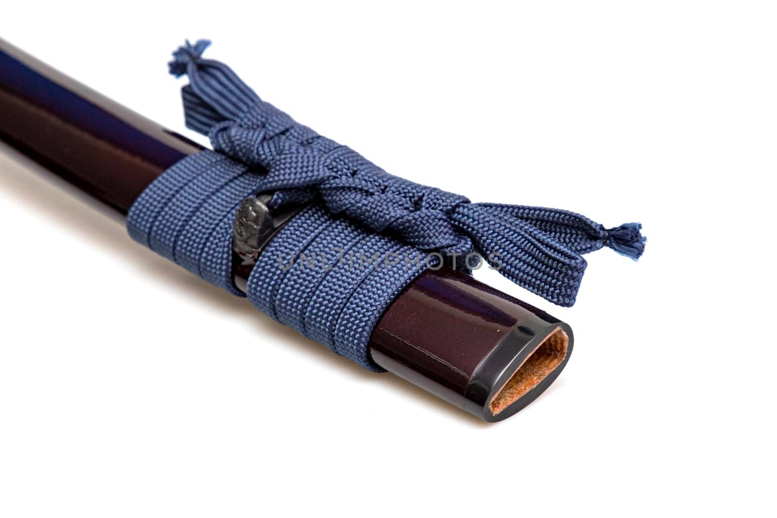 Navy Blue Sageo : Navy blue silk rope for tying. Shining crimson Japanese scabbard isolated on a white background. Selective focus.