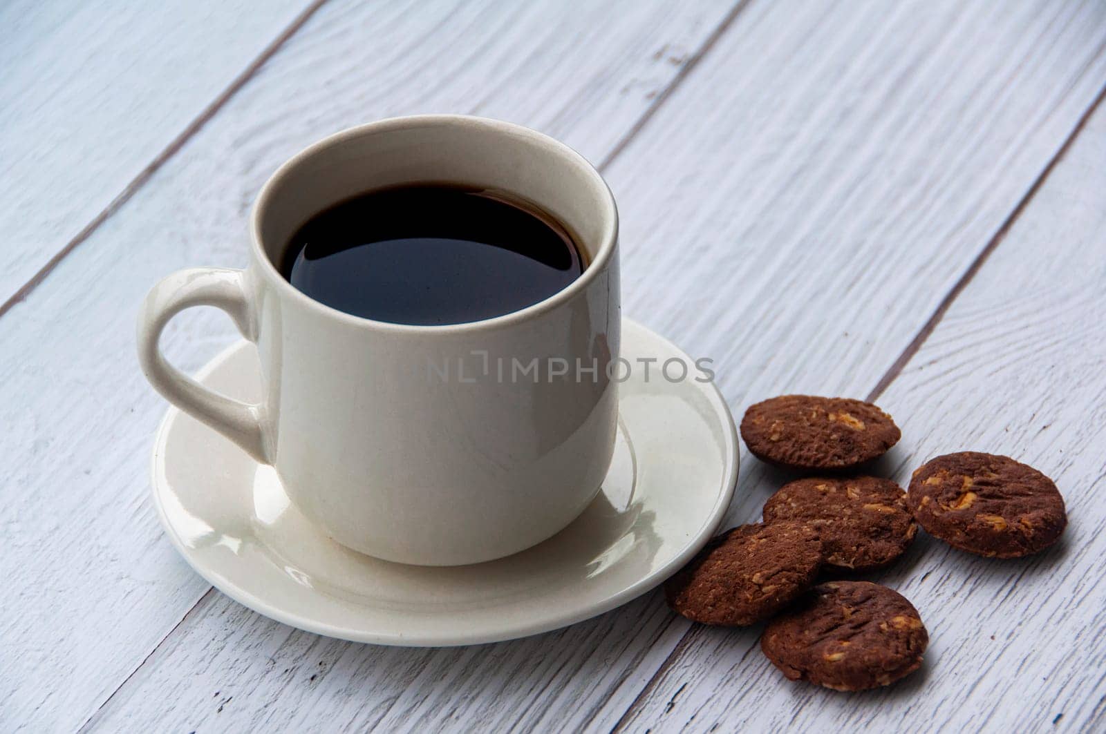 Coffee cup and cookies on wooden floor with customizable space for text or ideas. Copy space.