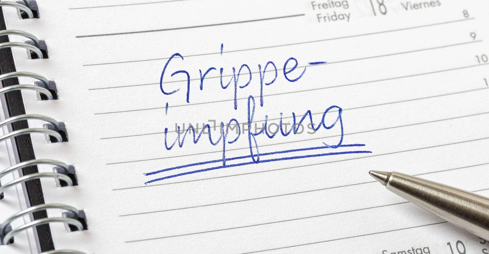 Influenza Vaccination written on a calendar page in german - Grippeimpfung