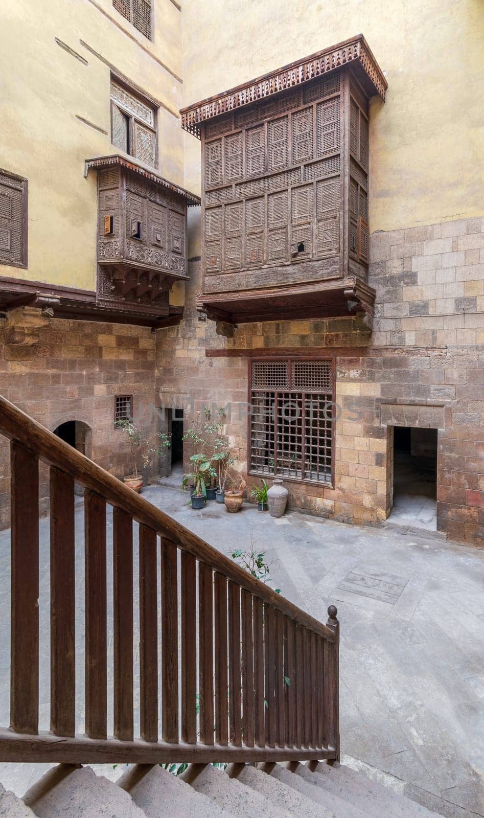 Staircase with wooden balustrade revealing facade of ottoman era historic house of El Sehemy with wooden oriel windows - Mashrabiya - located at Moez Street, Cairo, Egypt