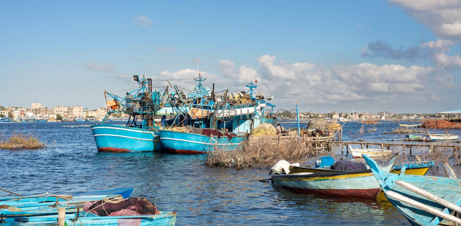 Fishing boats parked at River Nile in cloudy winter day, El Borg district, Rosetta City, Egypt