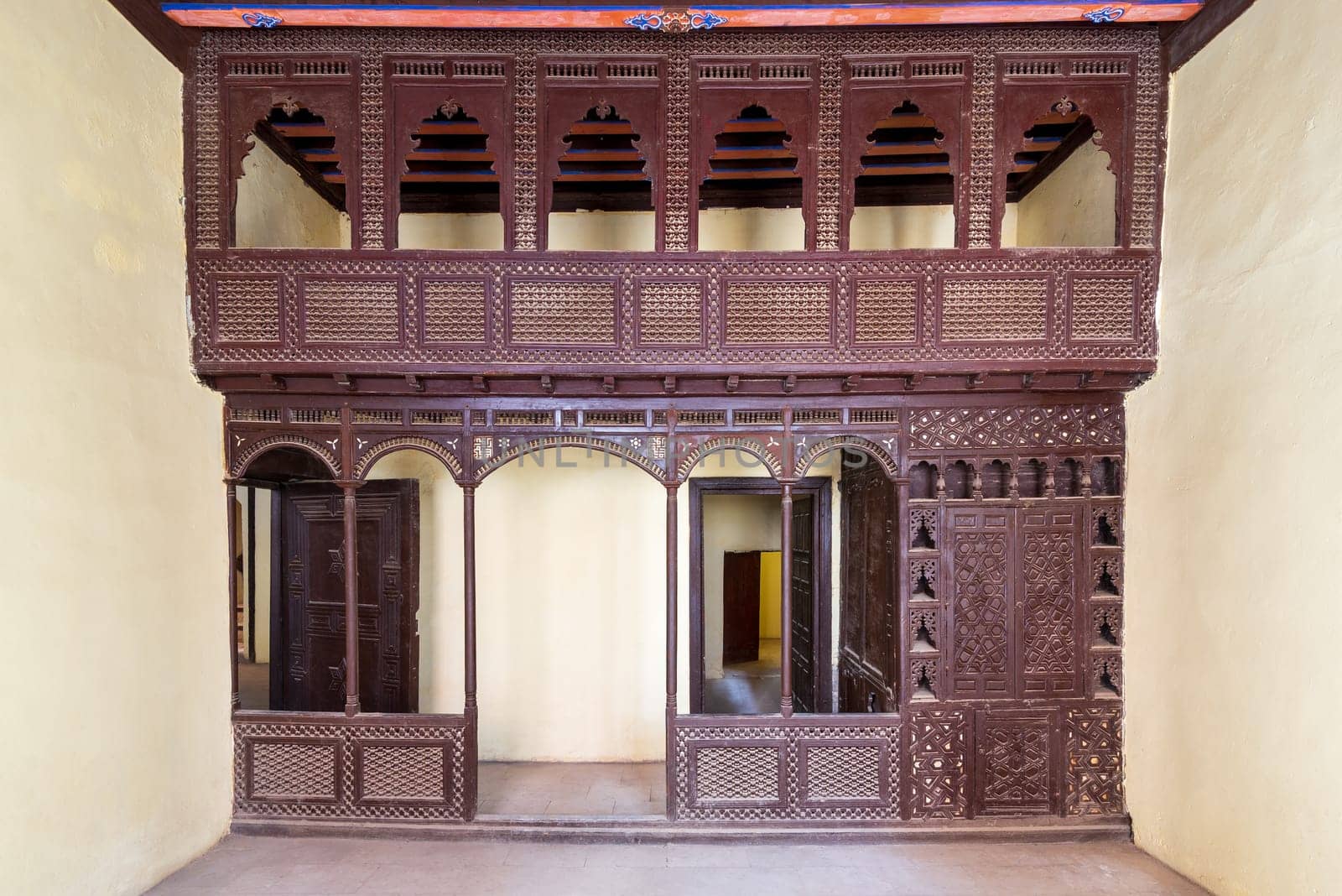 Oriental wooden engraved arabesque decorations with balcony installed in front of open doors inside empty spacious room