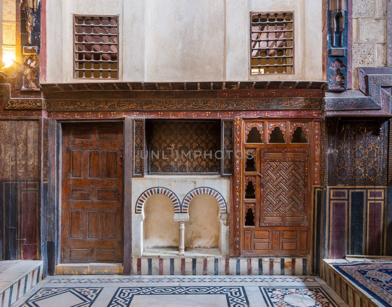 Wooden painted floral patterns, embedded arched niche, wooden door, wooden engraved cupboard, calligraphy decoration, and marble floor with geometric pattern at El Sehemy ottoman era historic house