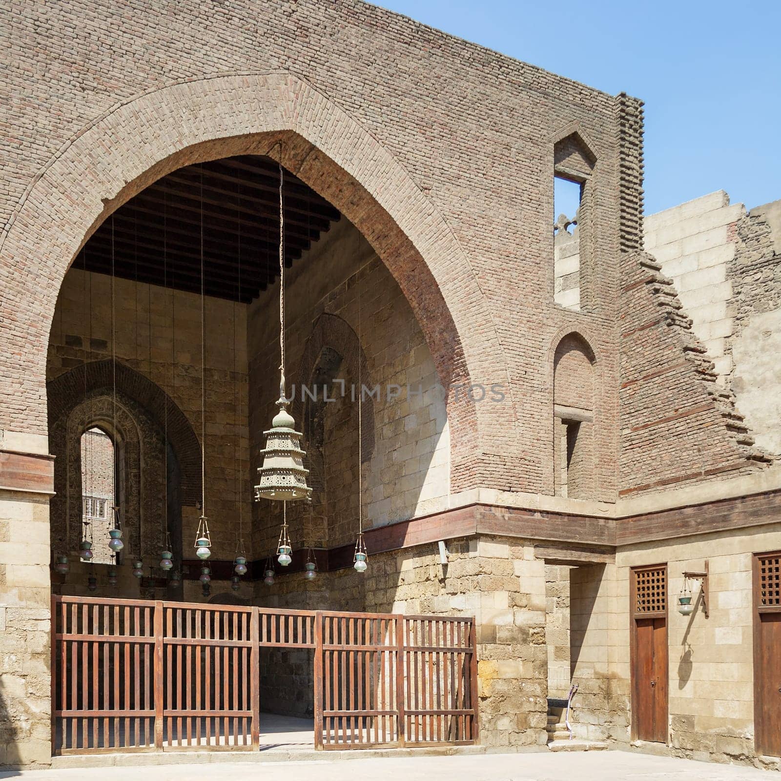 Main courtyard of public historic mosque of Sultan Al Nassir Qalawun with huge arch, Cairo, Egypt