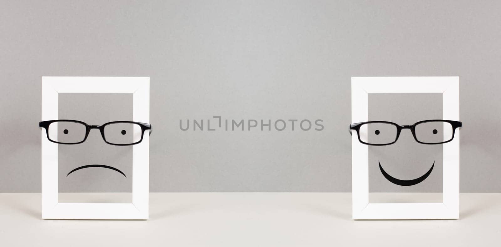 Frame with a sad and a happy face with eyeglasses, mental health concept, positive and negative mindset, depression, support and evaluation symbol, emotion