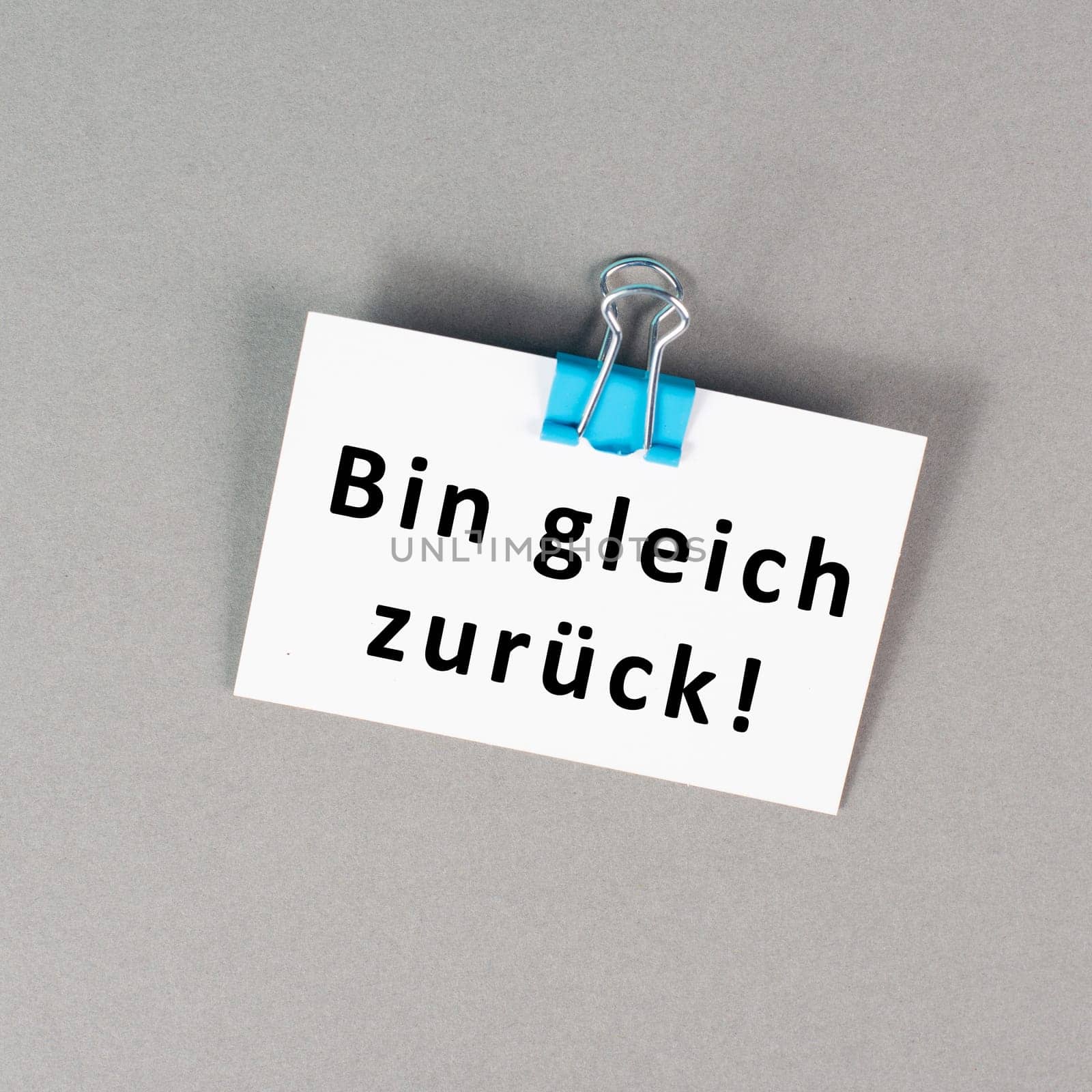I will be back soon is standing in german language on a paper, taking a break, leaving a message on the desk
