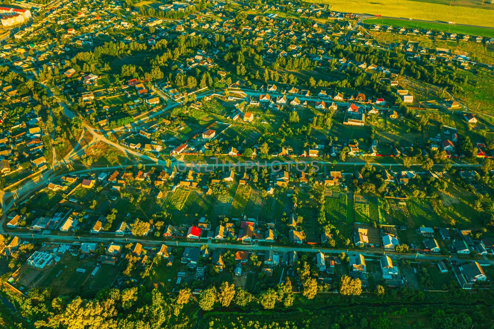 Aerial View Of Vegetable Gardens In Small Town Or Village. Skyline In Summer Evening. Village Garden Beds In Bird's-eye View.