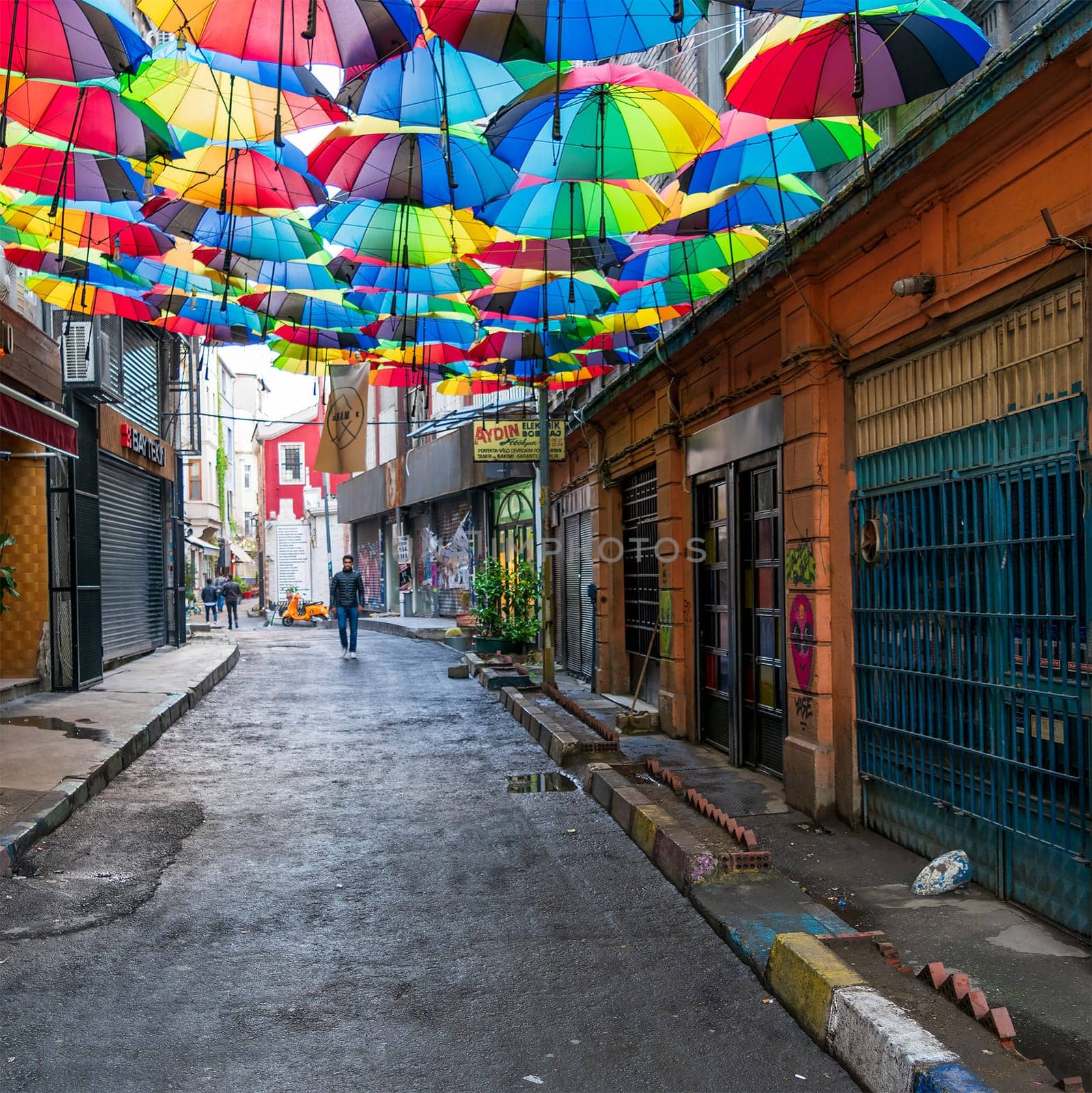 Istanbul, Turkey - April 18, 2017: Hoca Tahsin Street at Karakoy district decorated with colorful umbrellas with few people walking before sunset