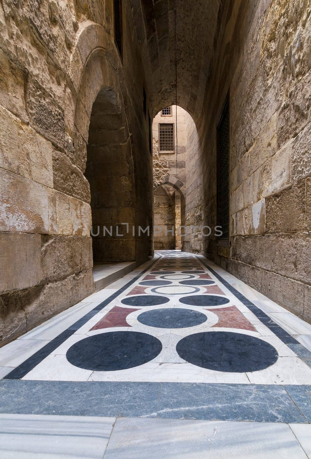Vaulted passage leading to the Courtyard of Sultan Qalawun mosque with geometrical pattern colorful marble floor, Moez Street, Old Cairo, Egypt