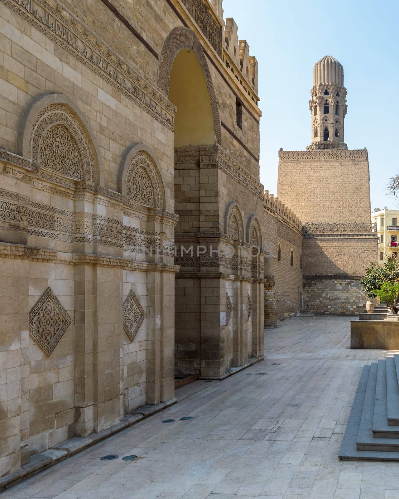 Entrance of public historic Al Hakim Mosque known as The Enlightened Mosque with Minaret in the far end, located in Moez Street, Old Cairo, Egypt