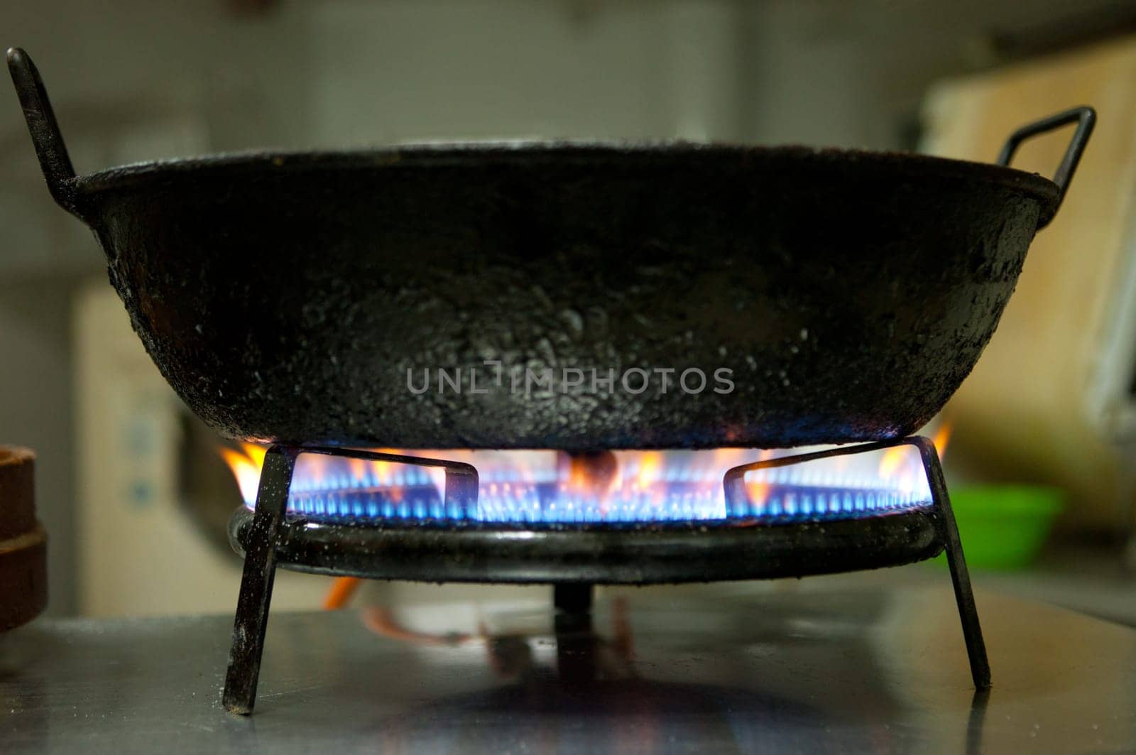 Big frying pan on the stove burning flame