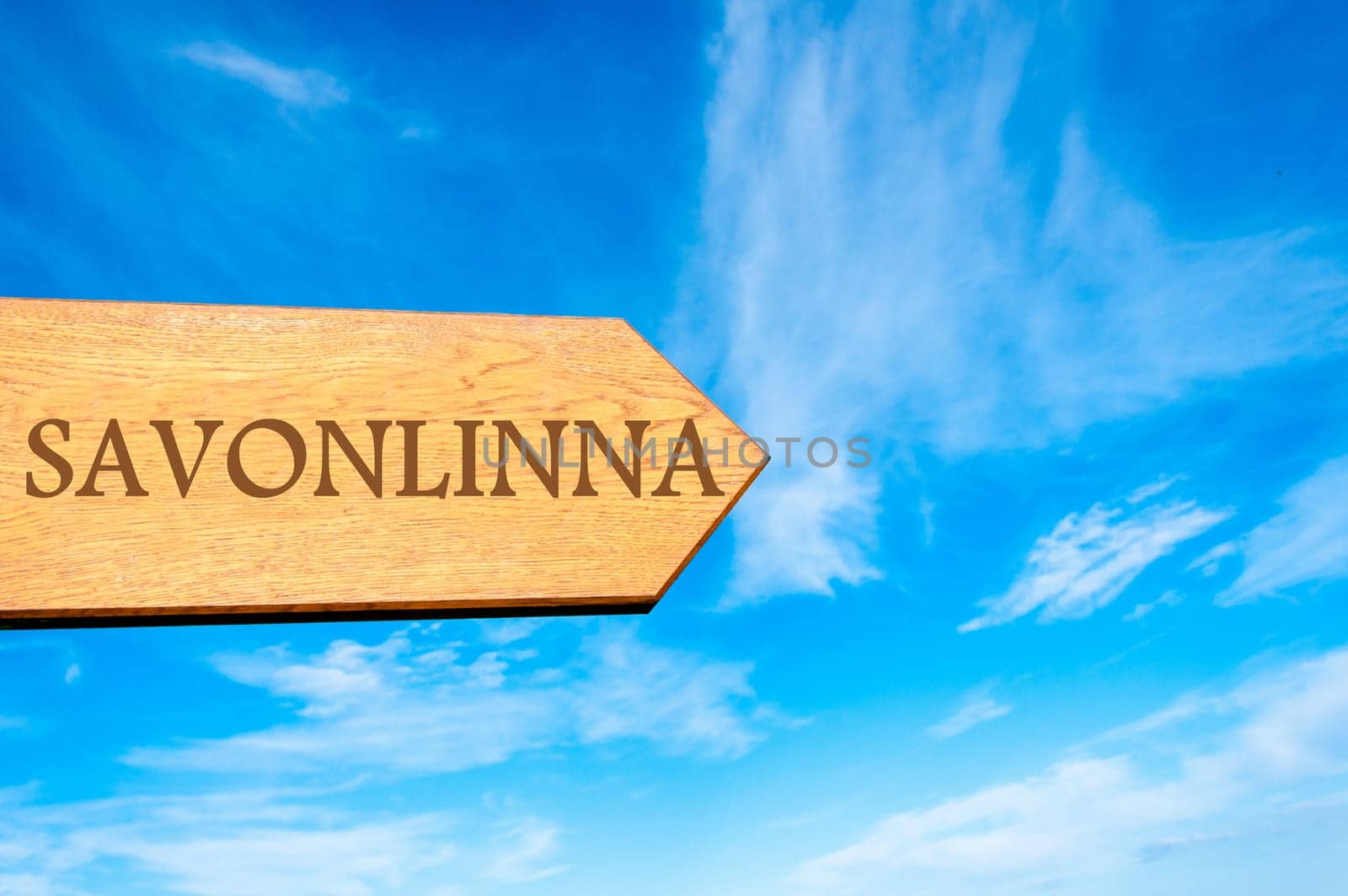 Wooden arrow sign pointing destination SAVONLINNA, FINLAND against clear blue sky with copy space available. Travel destination conceptual image