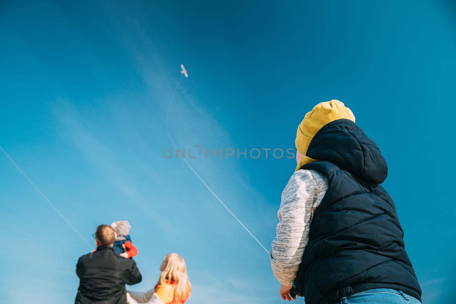 Caucasian Boy Of 6-7 Years Old Takes Up A Twine From A Kite. Pleasant Activity In Fresh Air On A Sunny Spring Or Autumn Day.