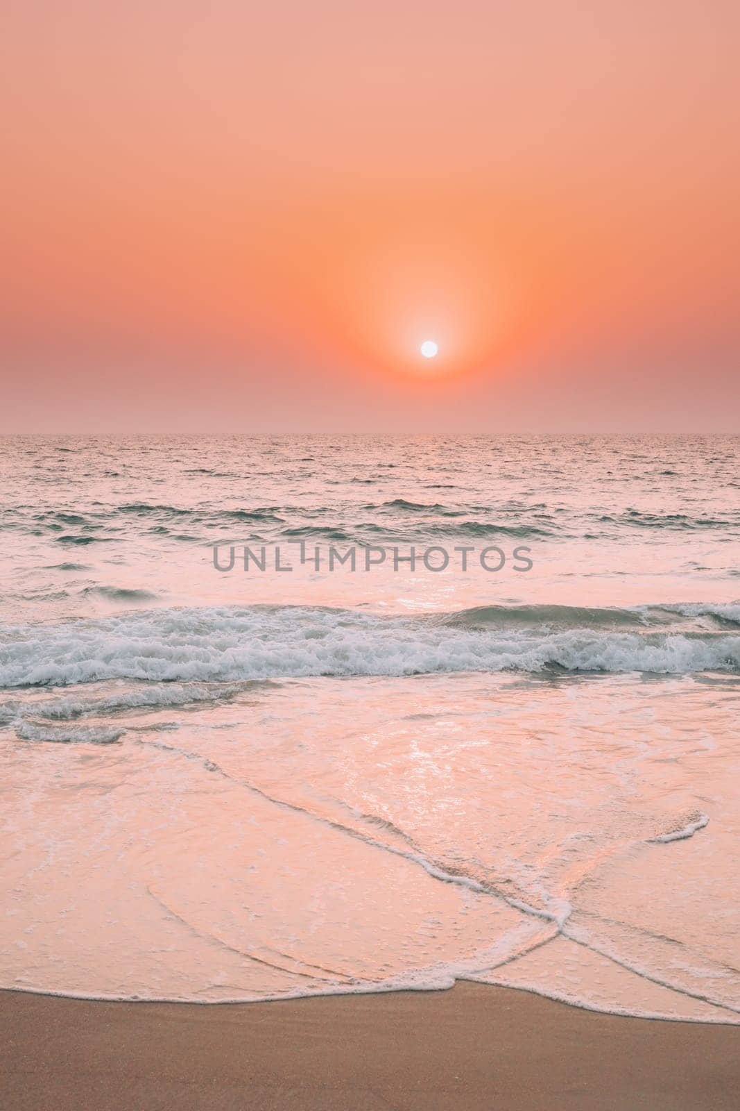 Sunset Sun Shine Above Sea. Natural Sunrise Sky Warm Colors Over Ripple Sea. Ocean Water Foam Splashes Washing Sandy Beach.