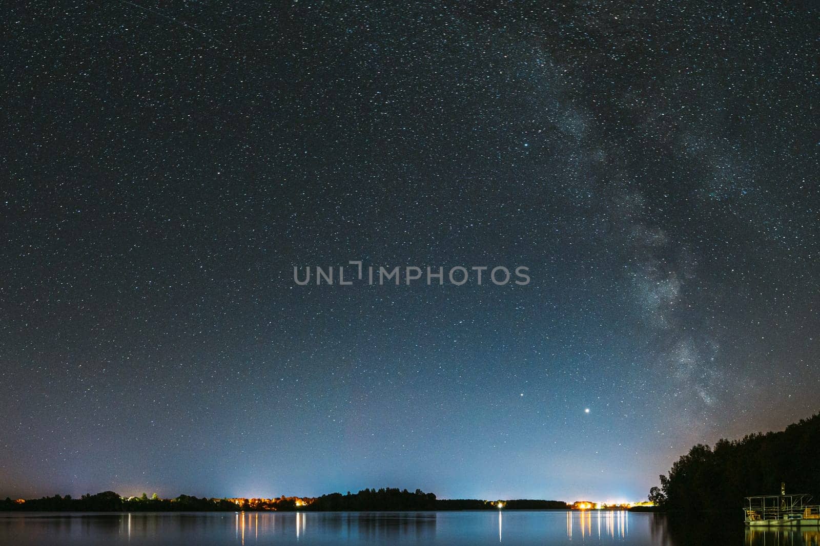 Village Novoye Lyadno, Lyepyel District, Vitebsk Province, Belarus. Real Colorful Night Stars Above Lepel Lake. Natural Starry Sky Background Backdrop Landscape.
