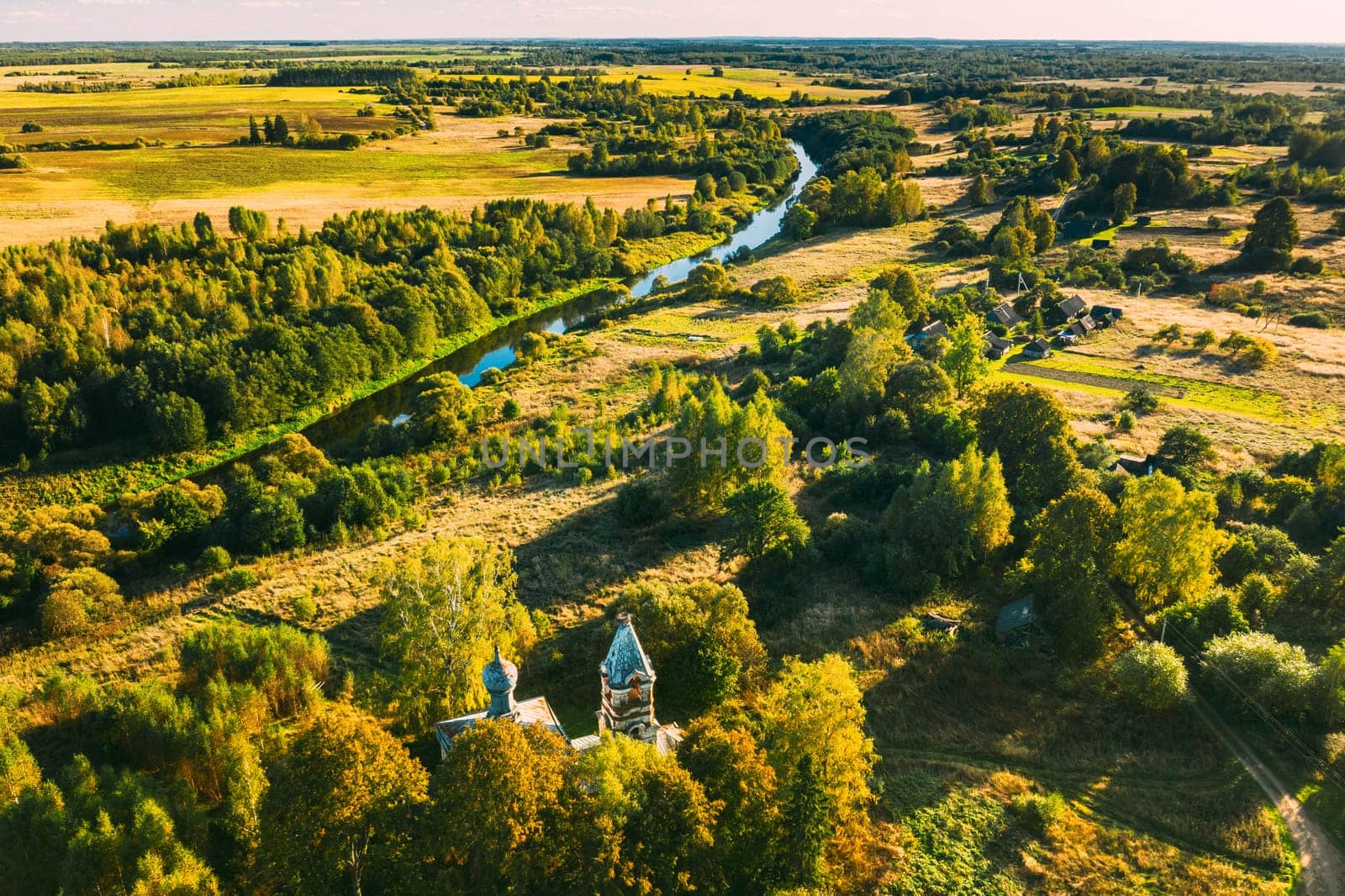 Martinovo, Beshenkovichsky District, Vitebsk Region, Belarus. Village Cityscape Skyline In Autumn Sunny Evening. Bird's-eye View Of Church Of The Intercession Of The Most Holy Theotokos. Aerial View Of Historic Landmark In Autumn Sunny Evening.