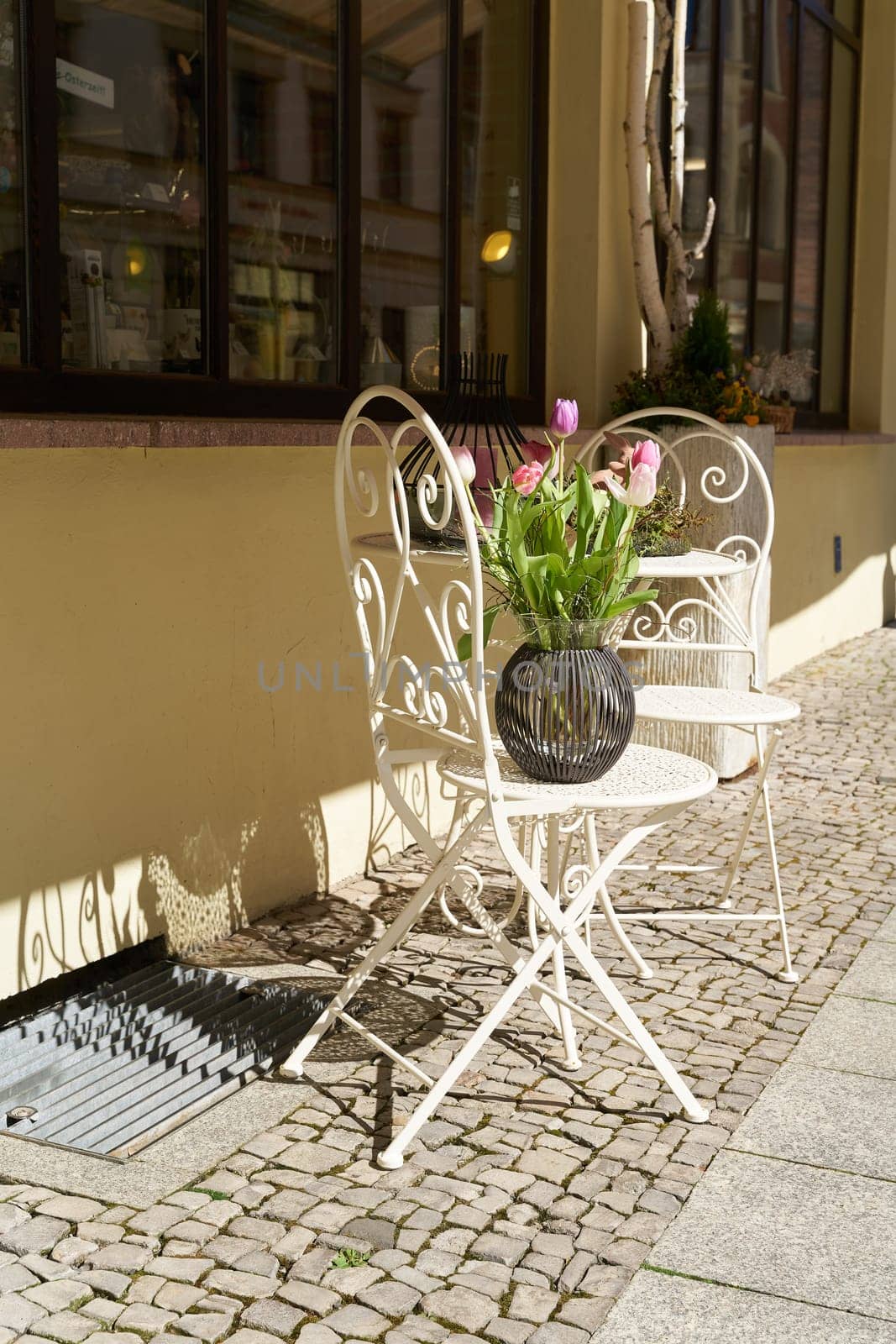 two chairs and a table in front of a store for decoration articles in a shopping street in Wittenberg in Germany