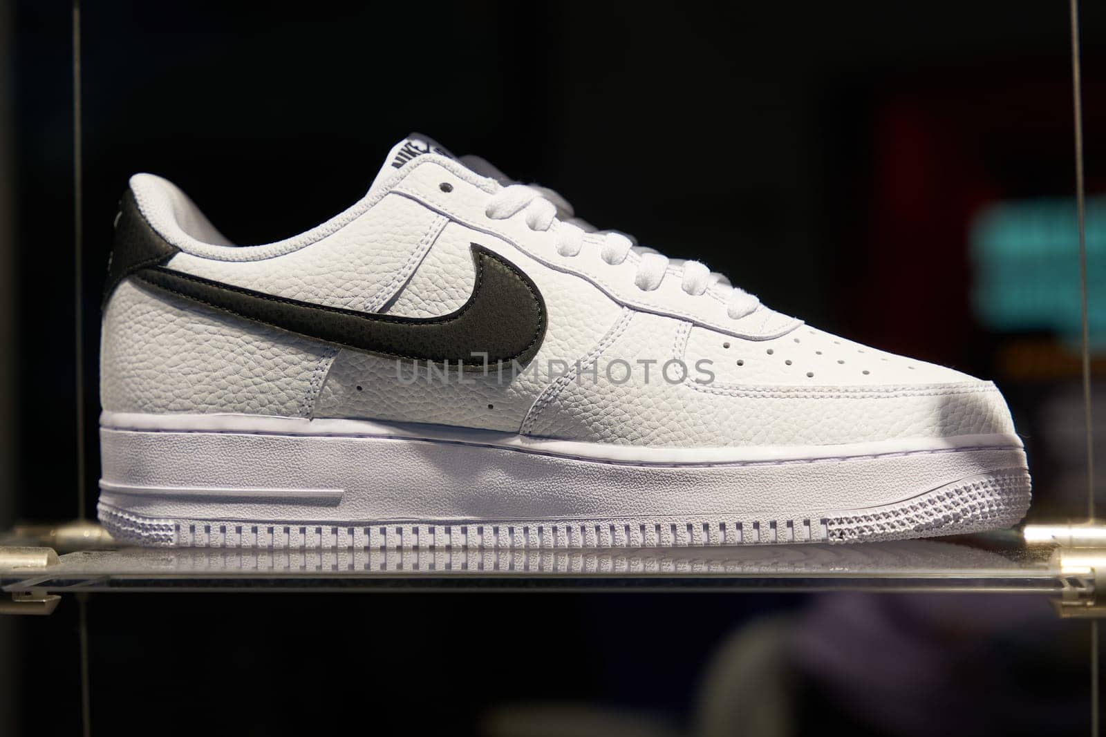 Shoe of the American sporting goods manufacturer Nike on a shelf in the illuminated shop window