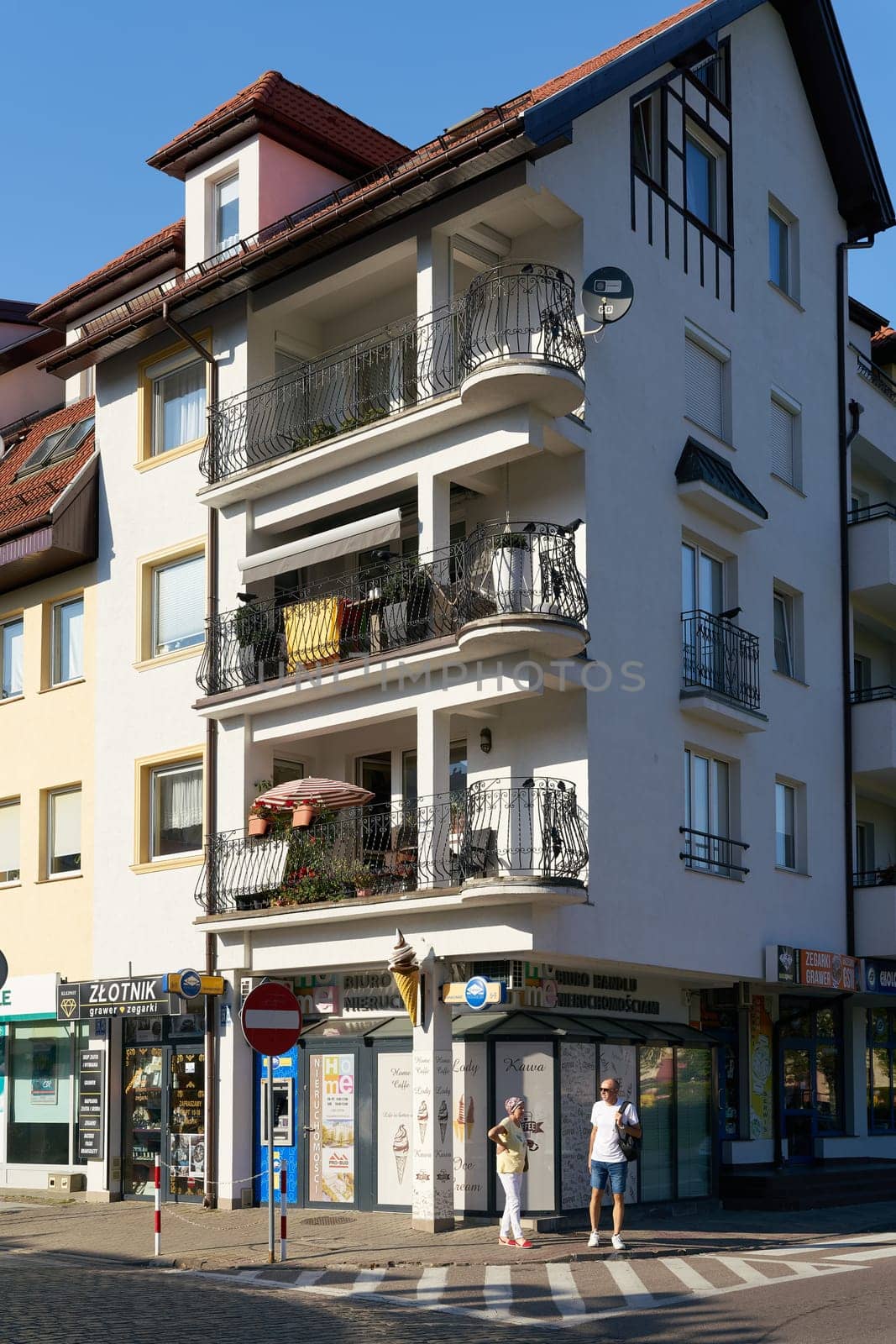 Shopping street with small stores and tourists in the center of Kolobrzeg in Poland