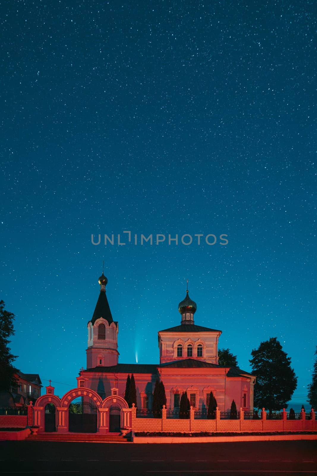 Korma Village, Dobrush District, Belarus. Comet Neowise C2020f3 In Night Starry Sky Above St. John The Korma Convent Church In Korma Village. Famous Orthodox Church And Historic Heritage.