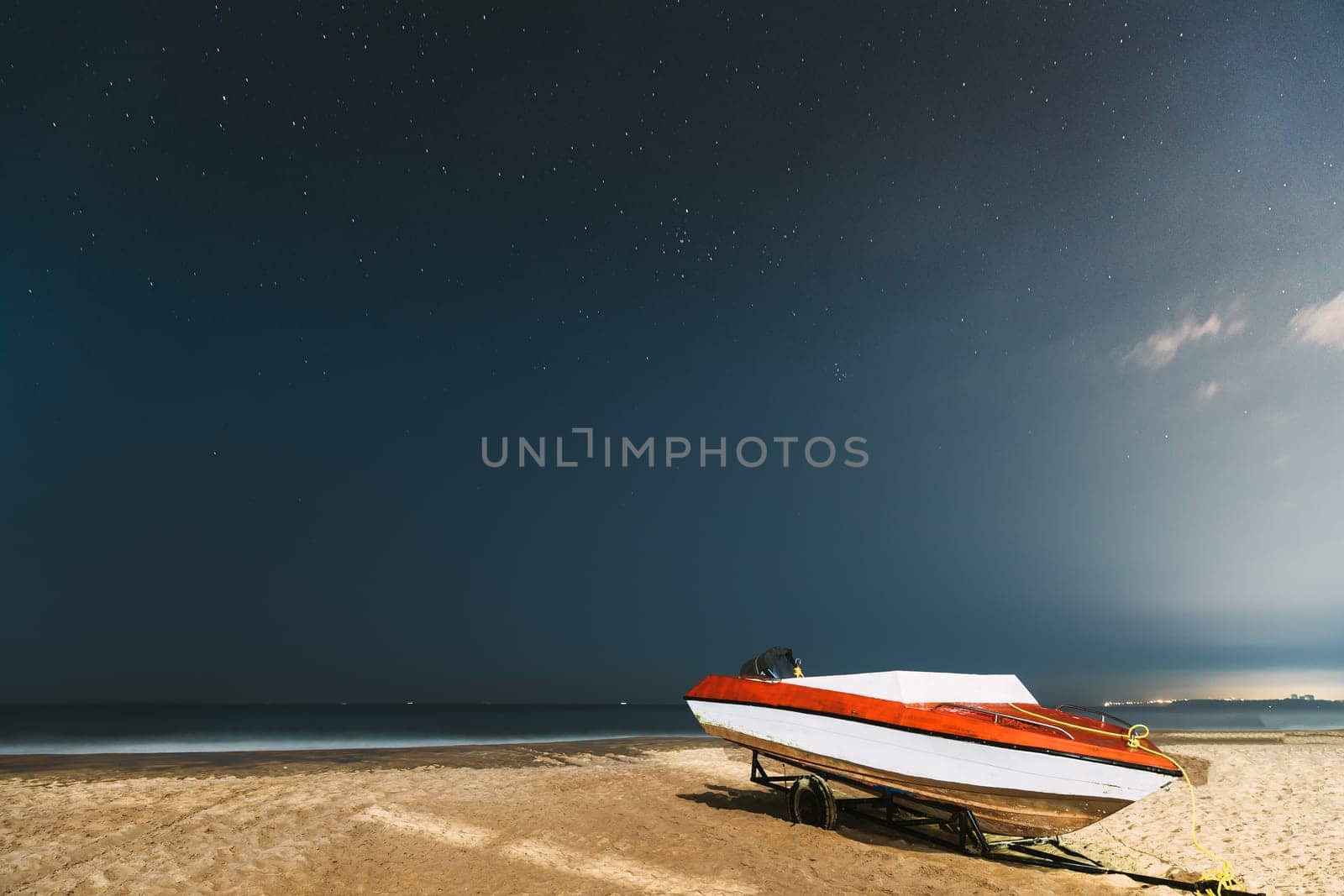 Goa, India. Real Night Sky Stars. Natural Starry Sky Blue Color Above Sea Seascape Ocean Beach. Background. Parked Boat At Coast.