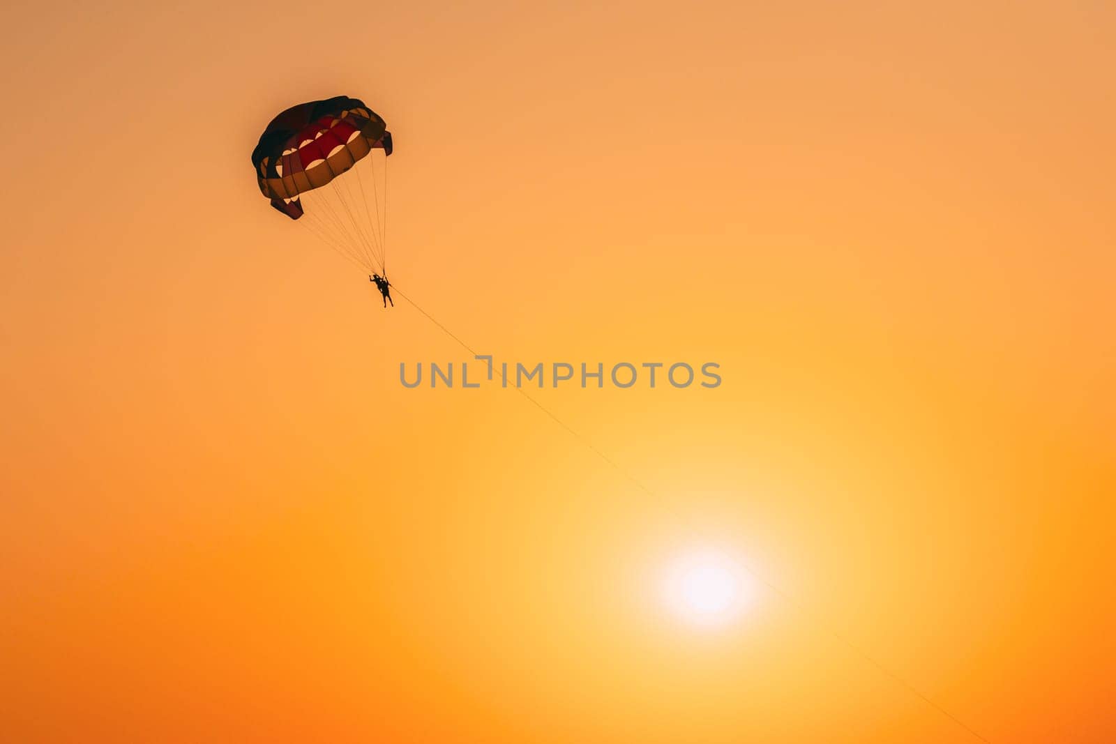 Parasailers Flying On Colorful Parachute In Sunset Sunrise Sky. Active Hobby. Sunshine.