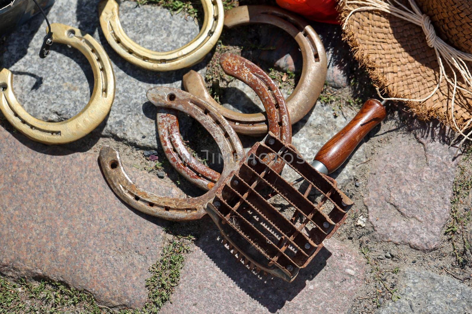 Several horseshoes and a tool for grooming, grooming horses.