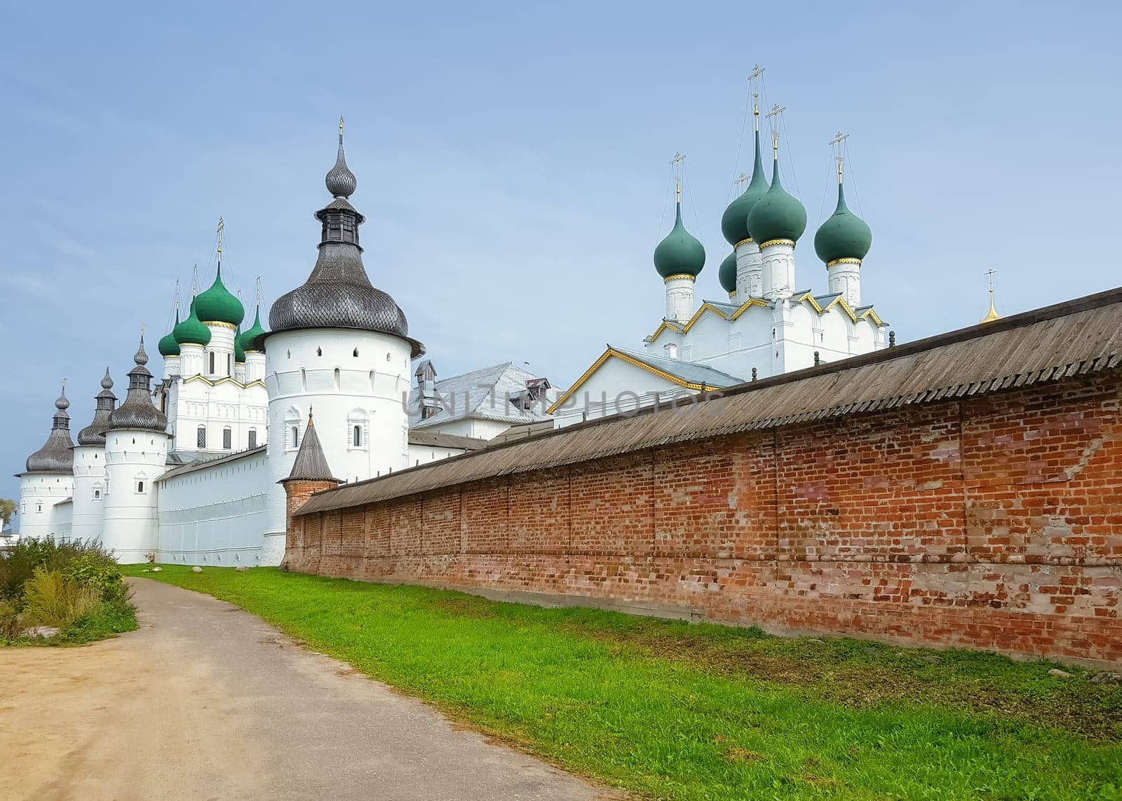 Rostov Veliky, Russia - September 13, 2021: Brick wall of the Rostov Kremlin with a view of the Tower of St. Gregory and the tops of the churches. Golden Ring of Russia.