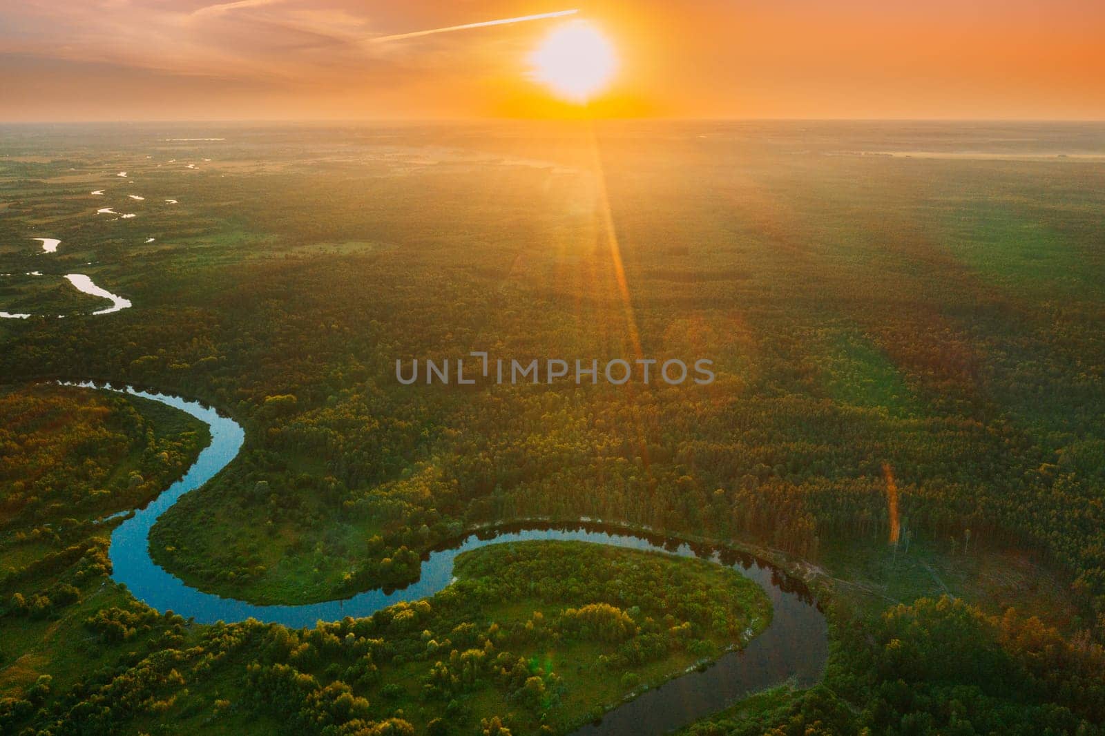 Belarus. Aerial View. Beautiful Sunset Sun Sunshine Above Summer Green Forest And River Landscape In Sunny Evening. Top View Of European Nature From High Attitude In Summer Sunrise. Bird's Eye View.