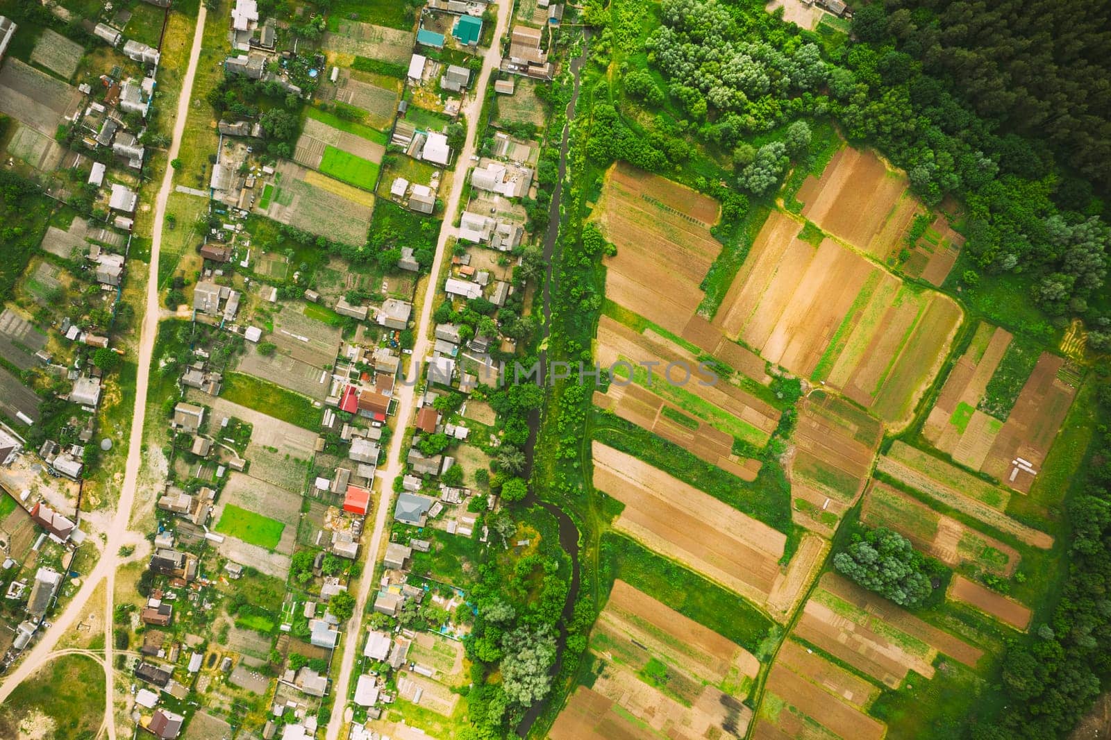 Aerial View Of Vegetable Gardens In Small Town Or Village. Skyline In Summer Evening. Village Garden Beds In Bird's-eye View.