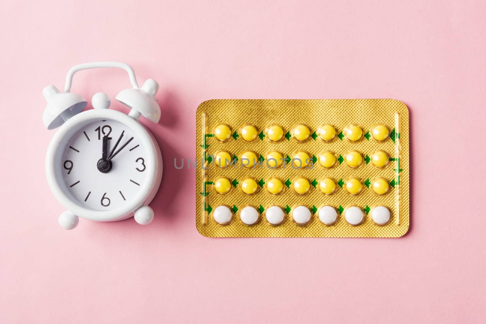 World sexual health or Aids day, Top view flat lay medicine birth control, alarm clock and contraceptive pills, studio shot isolated on a pink background, Safe sex and reproductive health concept
