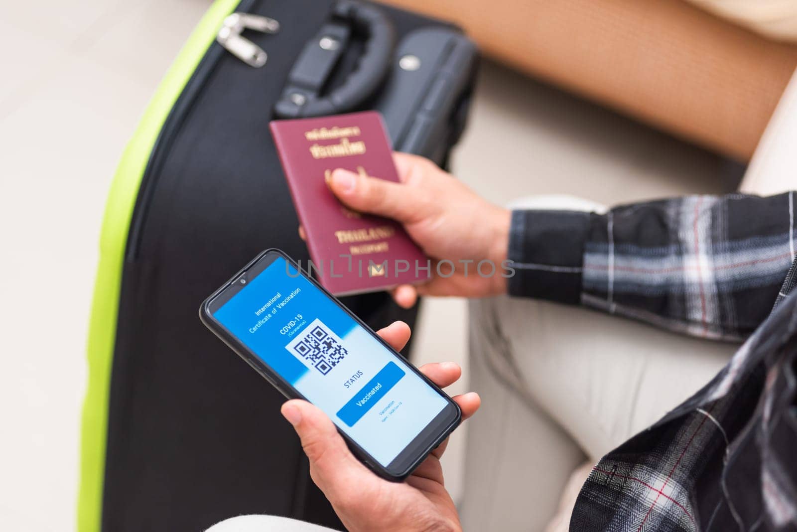 Vaccination passport, Traveler man holding health passport of vaccination certification on smartphone app at airport before boarding plane during coronavirus pandemic, Mobile app of virus COVID-19