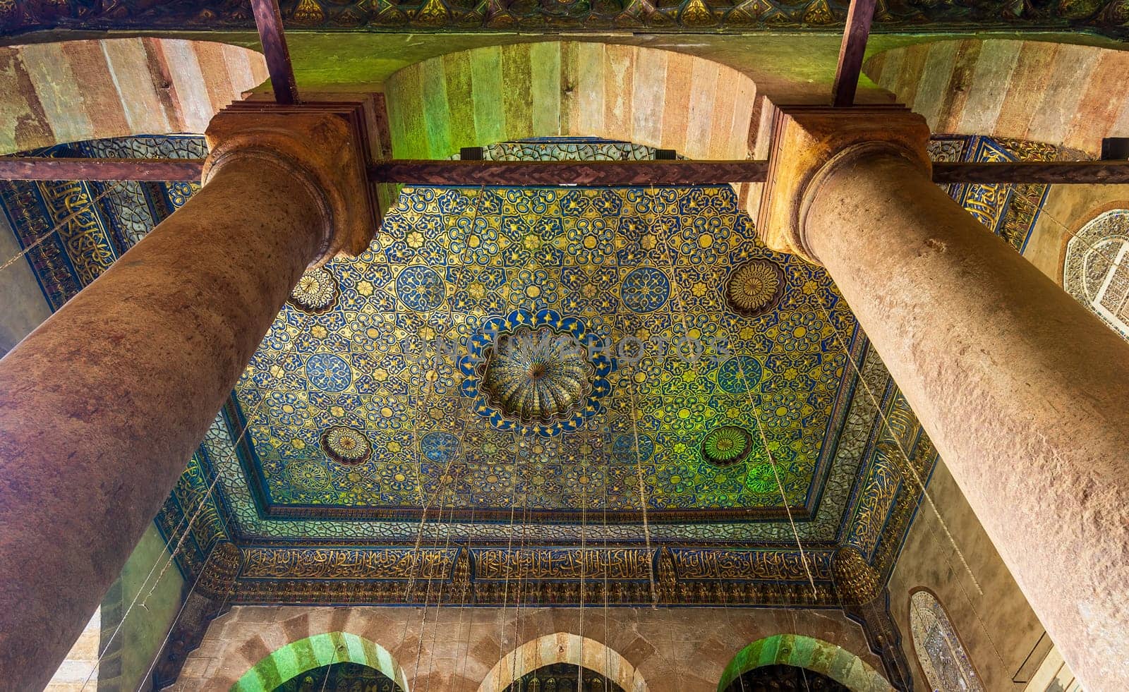 Ornate ceiling with blue and golden floral pattern decorations framed by two columns at Sultan Barquq mosque, Al Moez Street, Old Cairo, Egypt