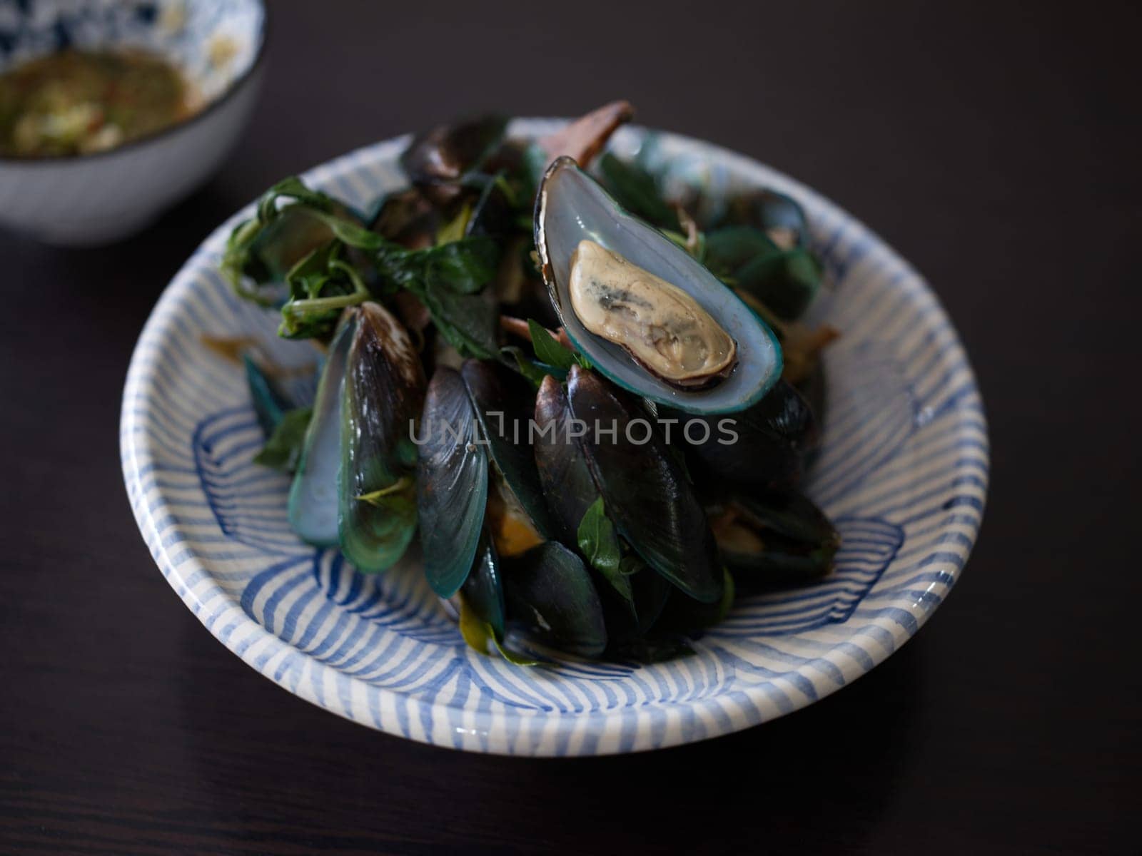 Thai Food steamed mussels with basil . Eaten with spicy sauce.