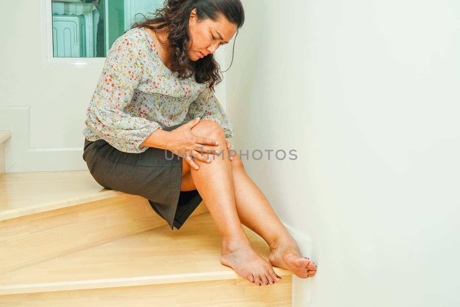 Asian senior woman wearing elastic support knee brace for reduce pain.