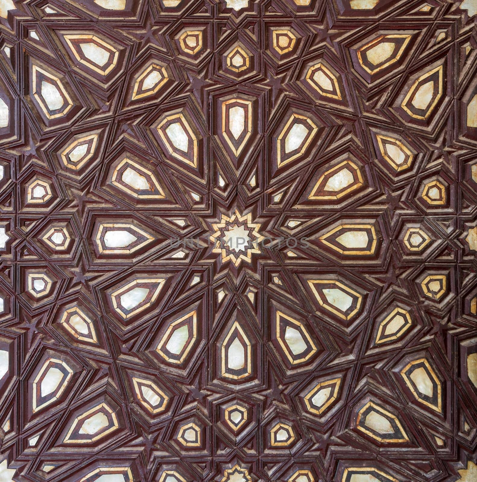 Closeup of wooden arabesque decorations tongue and groove assembled, inlaid with ivory and ebony, on old aged door, Rosetta City, Egypt