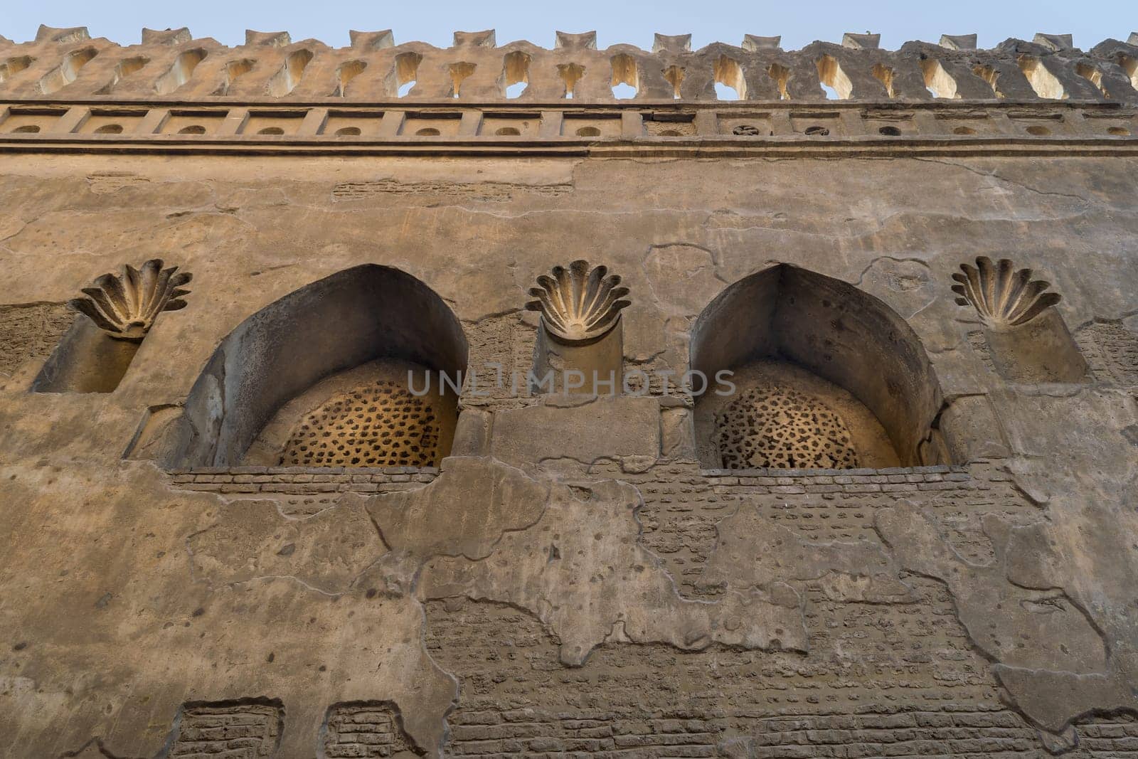 Two perforated arched stucco window decorated with floral patterns, one of the traditions of the Mamluk era, Outer wall of Mosque of Ibn Tulun, Sayyida Zaynab district, Medieval Cairo, Egypt