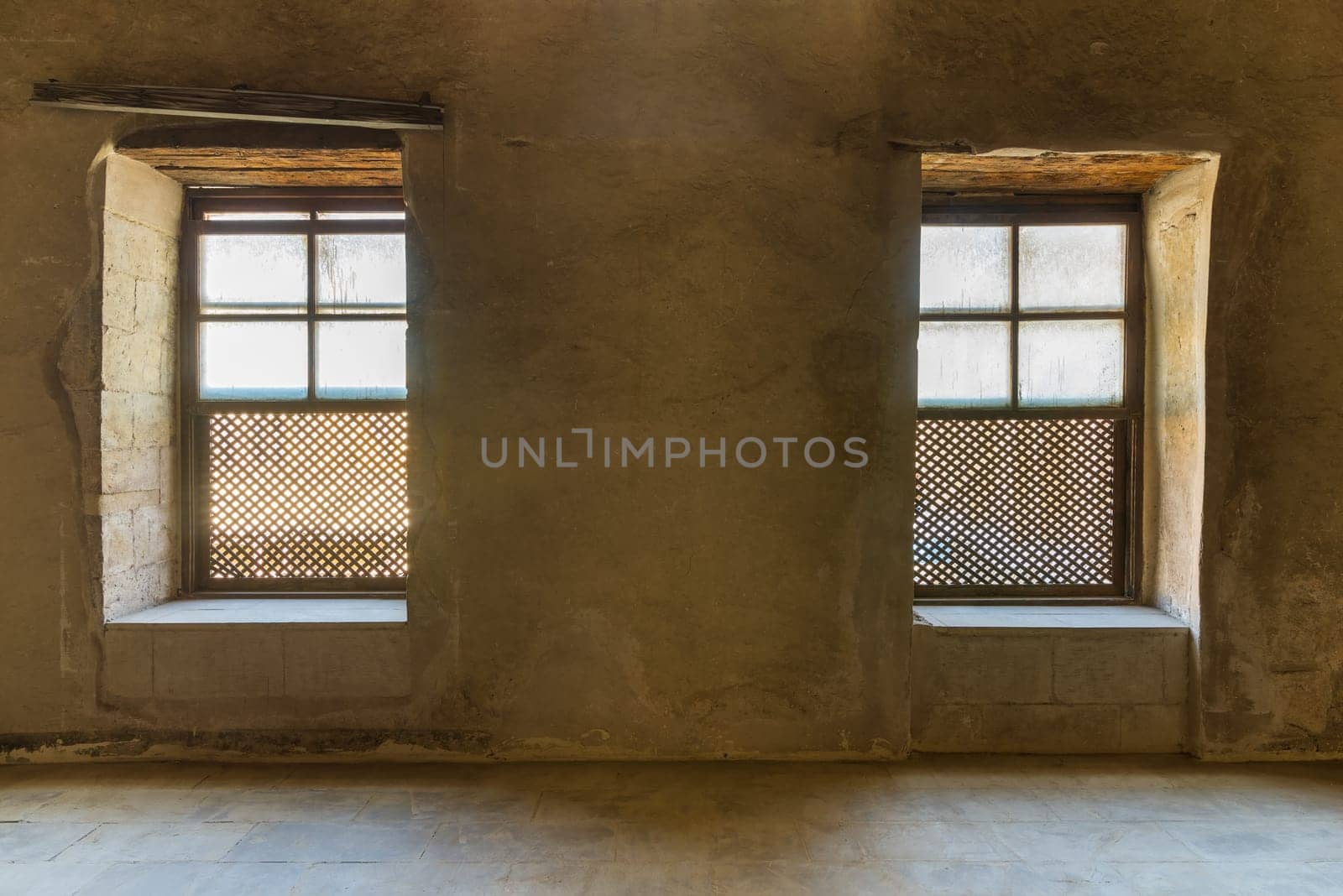 Two Interleaved grunge wooden ornate windows - Mashrabiya - in stone wall at abandoned building, Medieval Cairo, Egypt