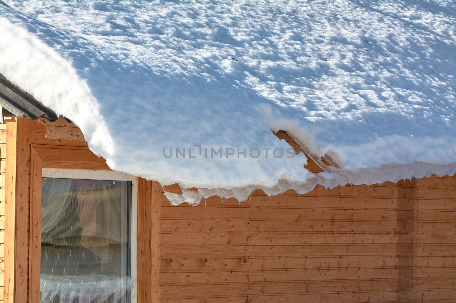 a block of ice hangs from the roof of the house. High quality photo