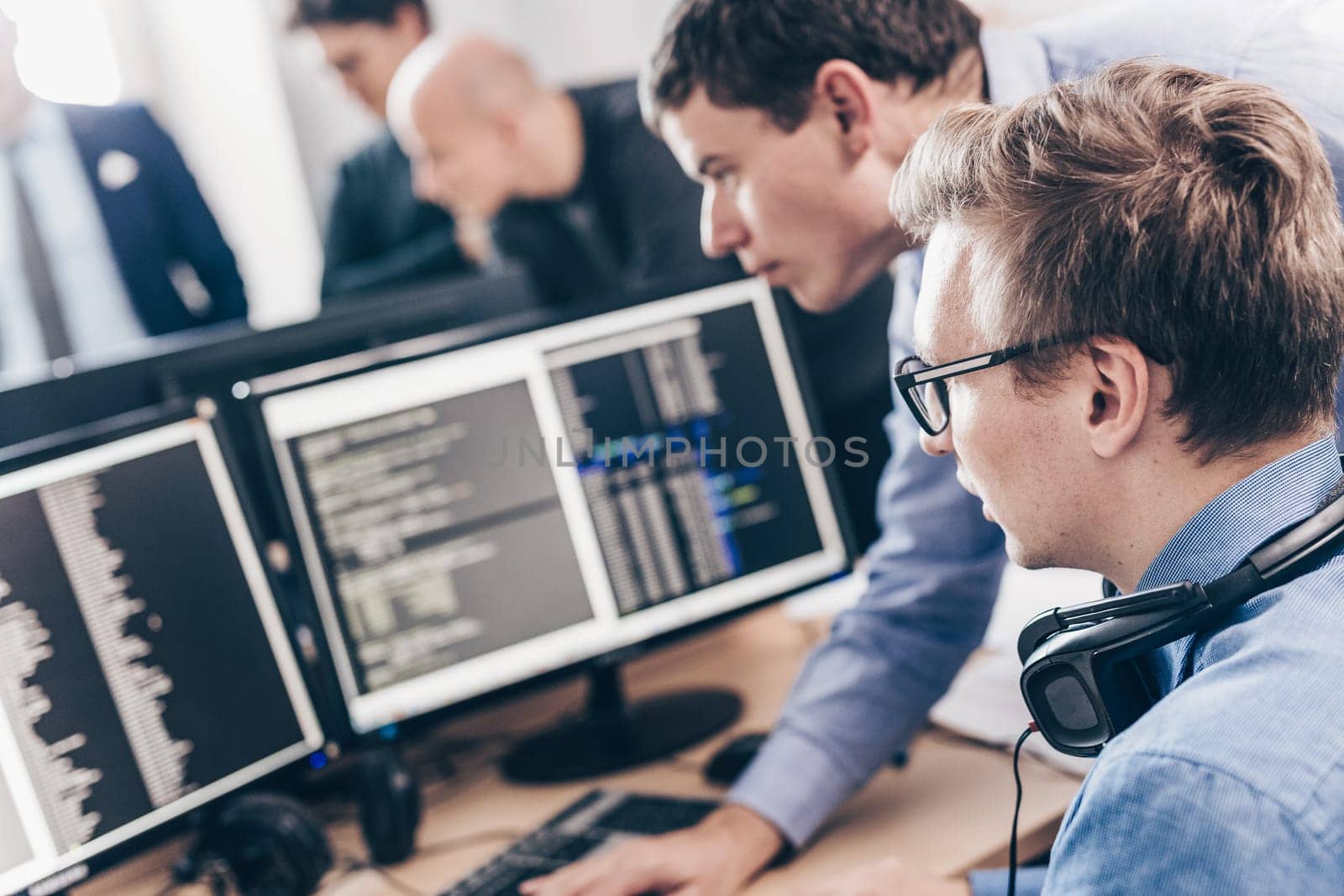 Startup business and entrepreneurship problem solving. Young AI programmers and IT software developers team brainstorming and programming on desktop computer in startup company share office space.