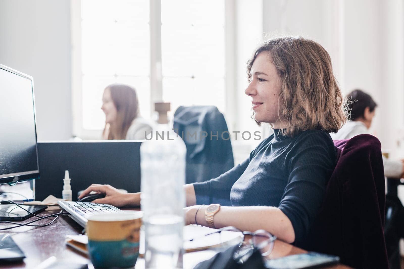 Women in startup business and entrepreneurship. Yound devoted female AI programmers and IT software developers team programming on desktop computer in startup company share office space.