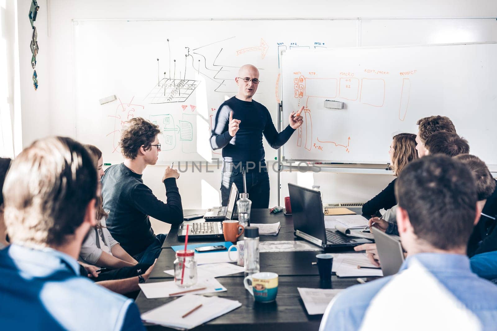 Relaxed informal IT business startup company meeting. Team leader discussing and brainstorming new approaches and ideas with colleagues. Startup business and entrepreneurship concept.