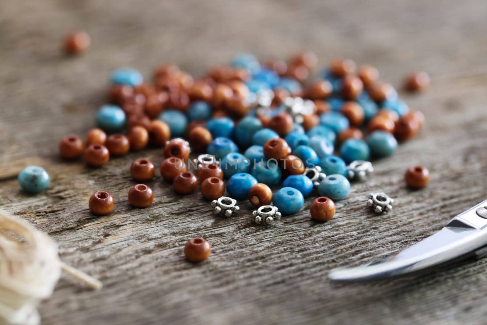 A pile of wooden turquoise, and metal beeds close up.